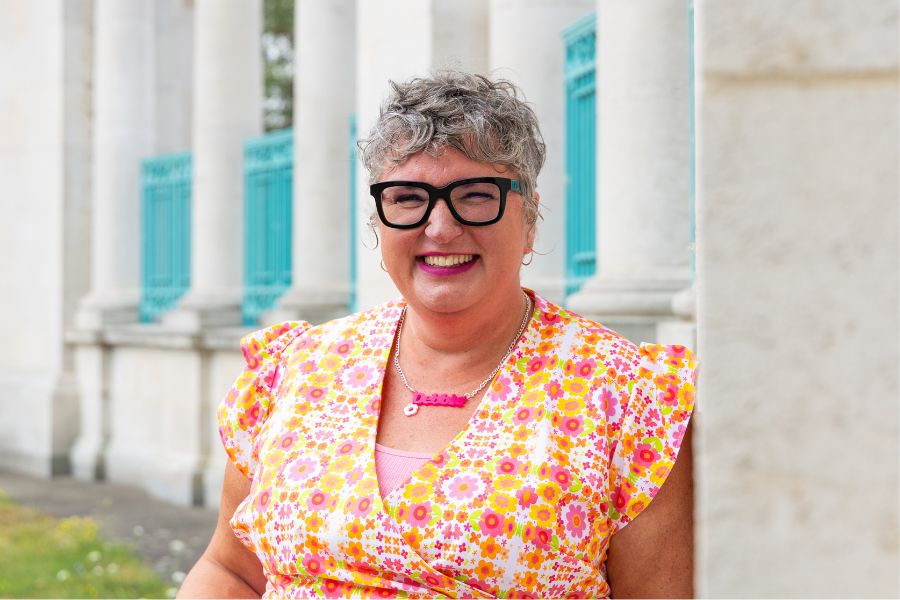 Debbie Draper The ADHD Coach leaning into a wall and smiling towards the camera